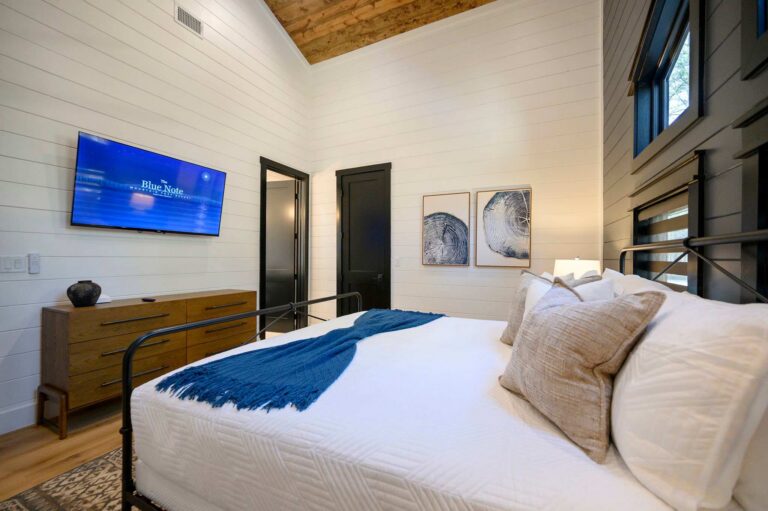 Luxury king bedroom inside Blue Note Broken Bow cabin with vaulted ceilings and modern rustic décor near Mountain Fork River activities.