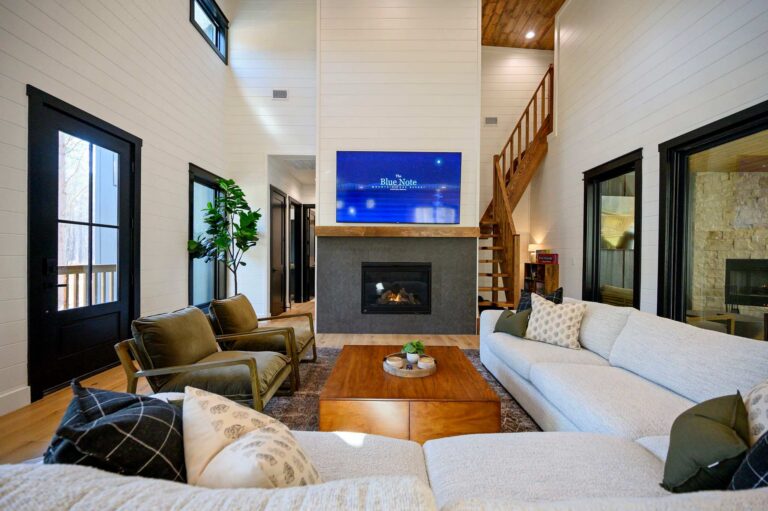 Large living room with fireplace inside Blue Note Broken Bow cabin near outdoor fire pit and river activities.