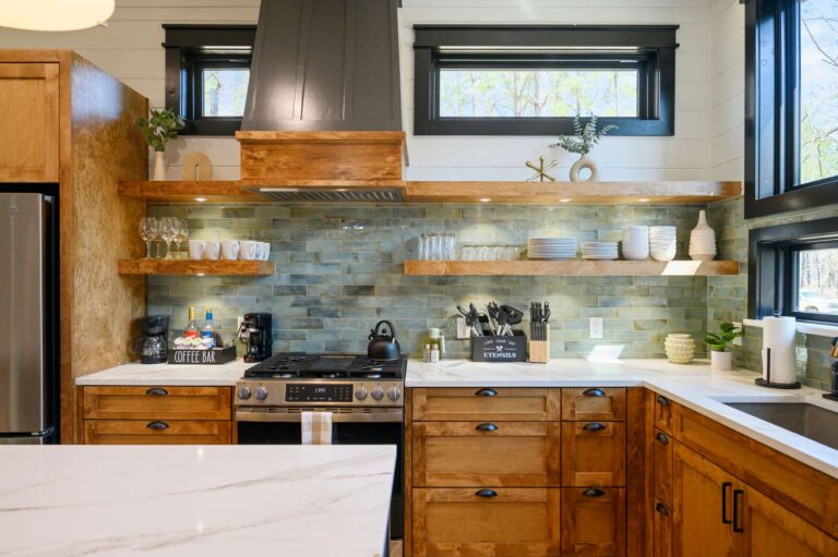 Modern kitchen design inside Blue Note Broken Bow cabin with custom shelving and cozy gathering spaces near outdoor fire pit.
