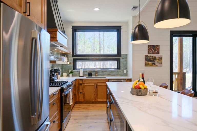 Luxury kitchen inside Blue Note Broken Bow cabin with large island, forest views, and access to river activities.