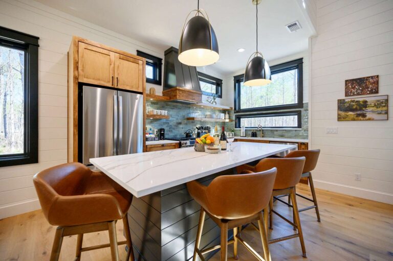 Modern kitchen island with seating inside Blue Note Broken Bow cabin near outdoor fire pit and river activities.