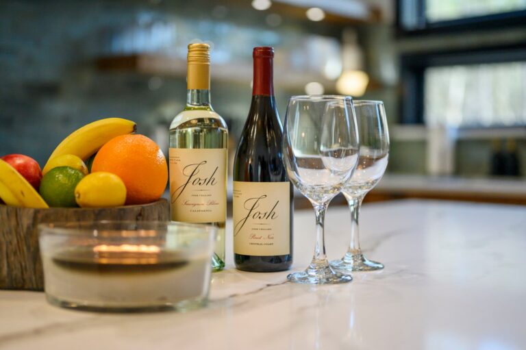 Wine bottles and glasses inside Blue Note Broken Bow cabin kitchen near outdoor fire pit and popular river activities.